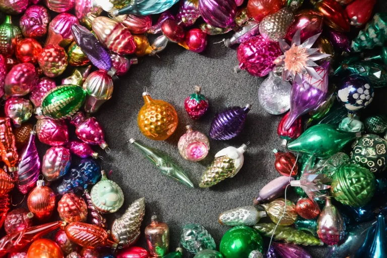An assortment of shiny and bright retro Christmas tree ornaments ranging from pink to green.