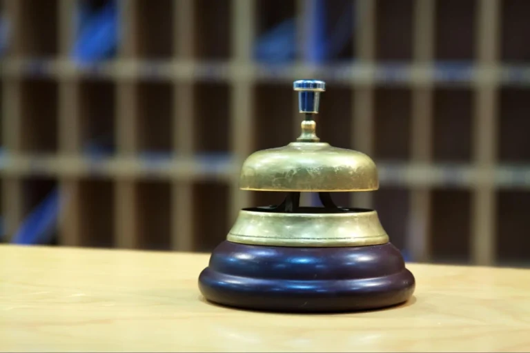 A brass call bell sitting on top of a counter.