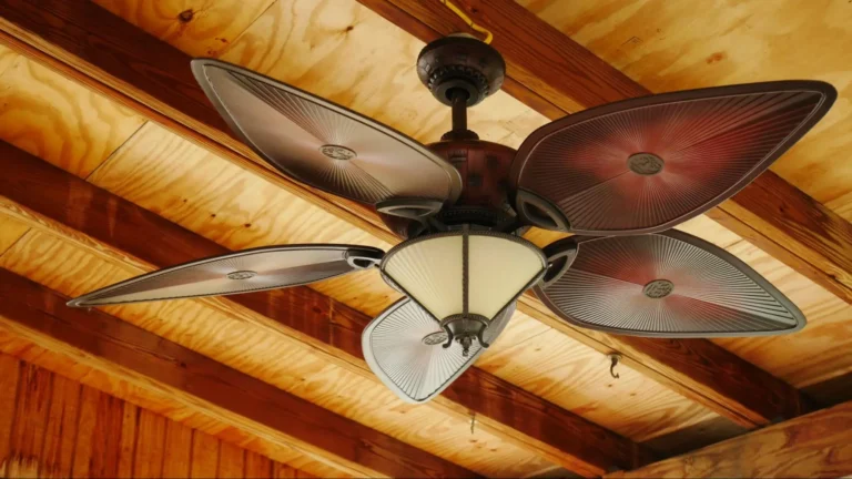 A vintage ceiling fan hanging from a ceiling with wooden beams.