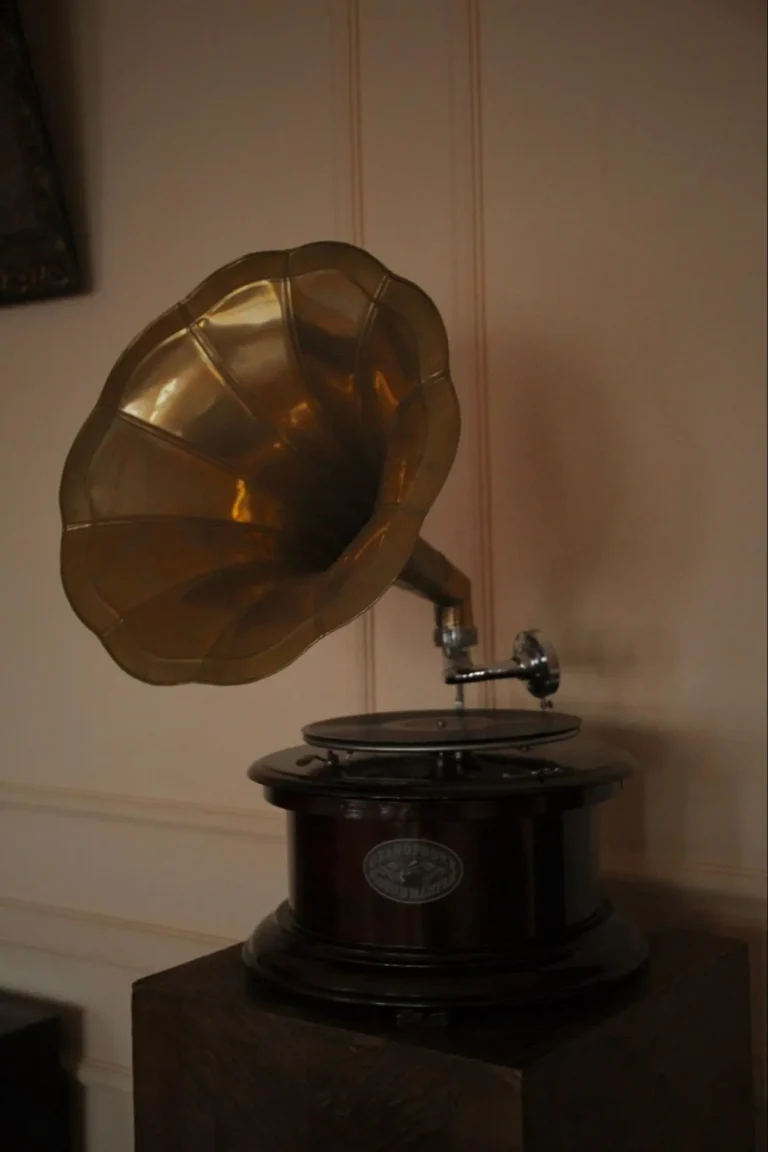 An antique gramophone with a gold-colored horn and a dark wooden base.