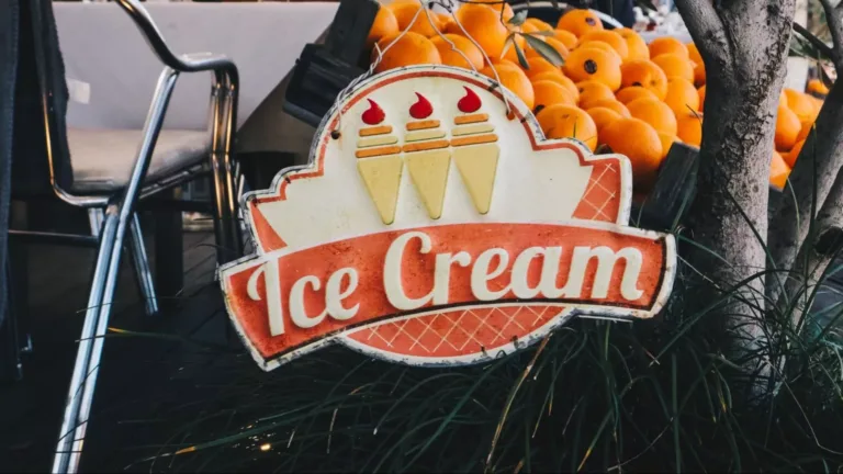 A vintage 1950s ice cream sign reading “Ice Cream” and featuring three ice cream images above it.