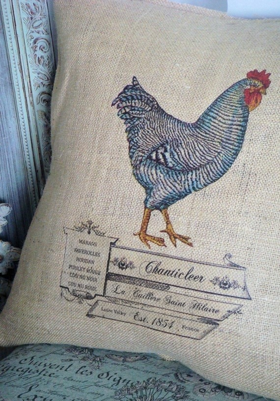 A burlap pillowcase with a vintage print of a rooster and vintage French labeling.