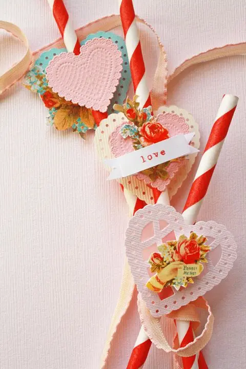 Vintage Valentine decorations made up of red and white candy sticks with openwork hearts and cut-out rose illustrations.