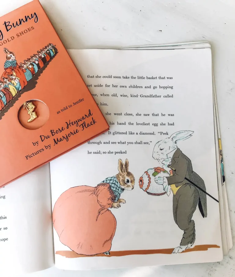 A book titled The Country Bunny lies open to a page featuring some text and an old-fashioned children’s book illustration of two bunnies.