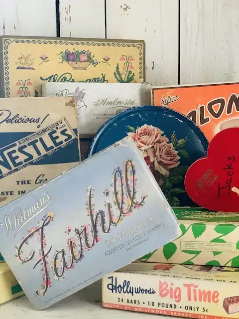 Various vintage chocolate and candy boxes such as Whitman’s and Nestle’s.