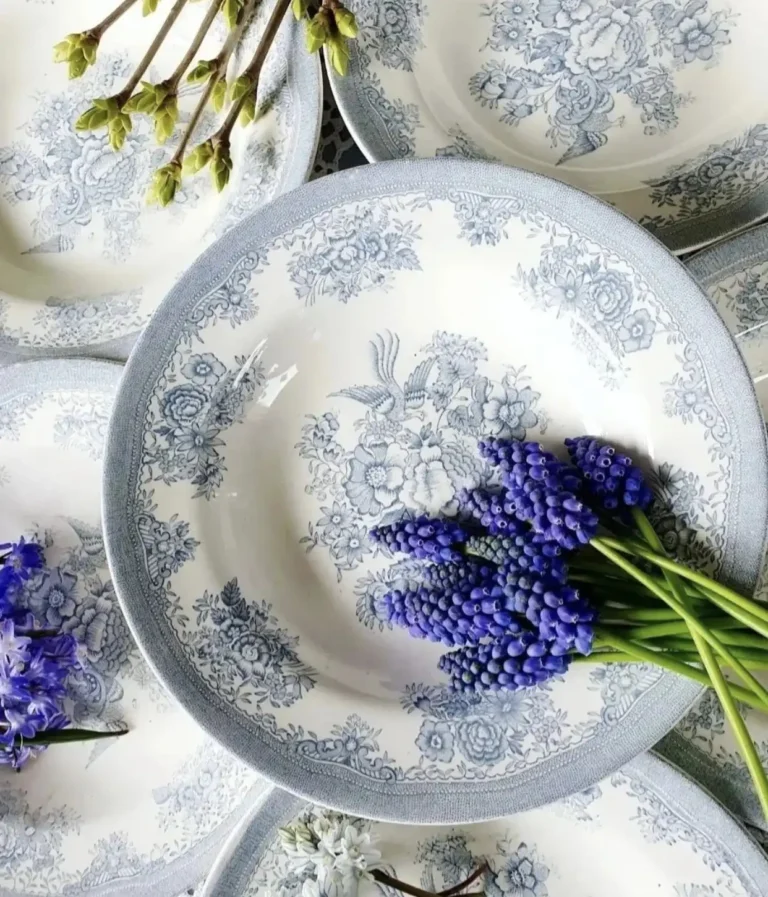 Top view of vintage blue and white English transferware featuring floral motifs, with grape hyacinth lying on top.