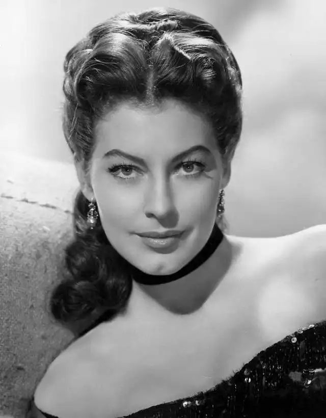 A black and white portrait of Hollywood star Ava Gardner wearing a black choker and crystal earrings.