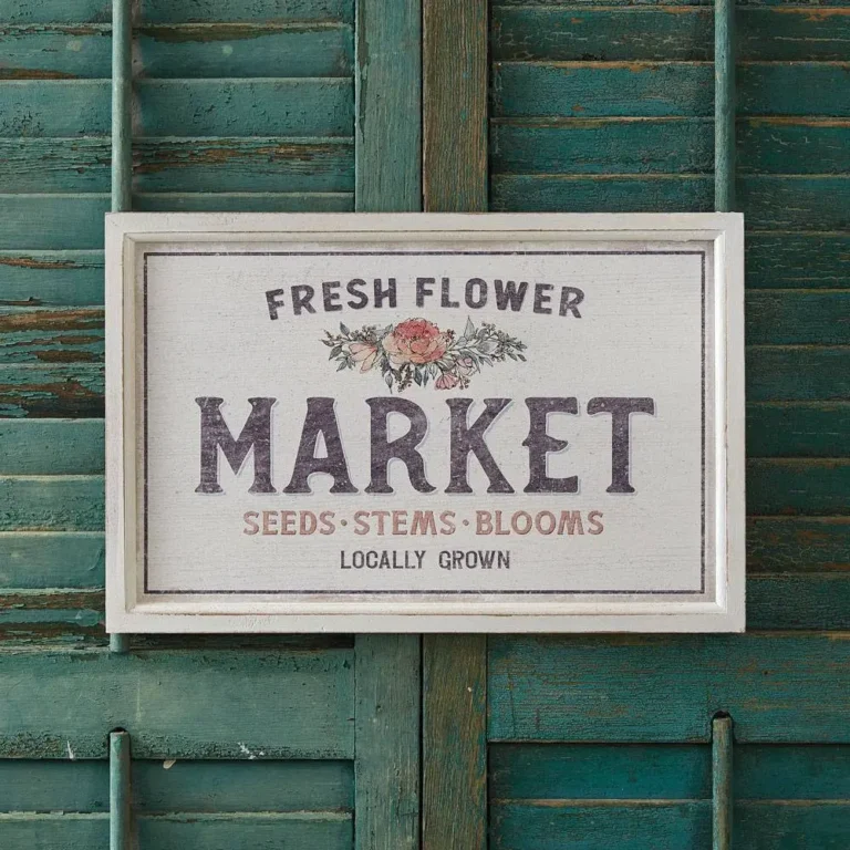 A wooden Fresh Flower Market sign hangs on a vintage washed dark green door.