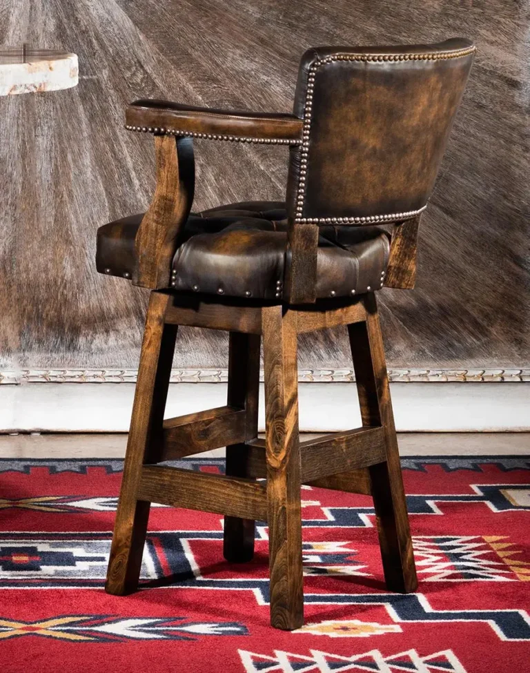 A dark brown leather and wood saloon bar stool on a red, yellow, and dark blue rug with a Native Indian pattern.