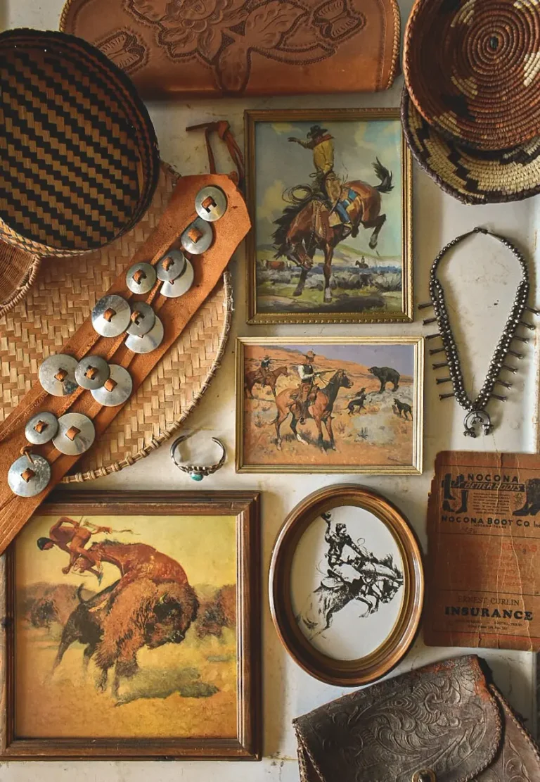 Various vintage Wild West-themed decorations hanging on a rustic wall, including vintage Old West artwork in square and oval frames, a vintage leather belt, a vintage leather bag, and vintage Native American turquoise jewelry.