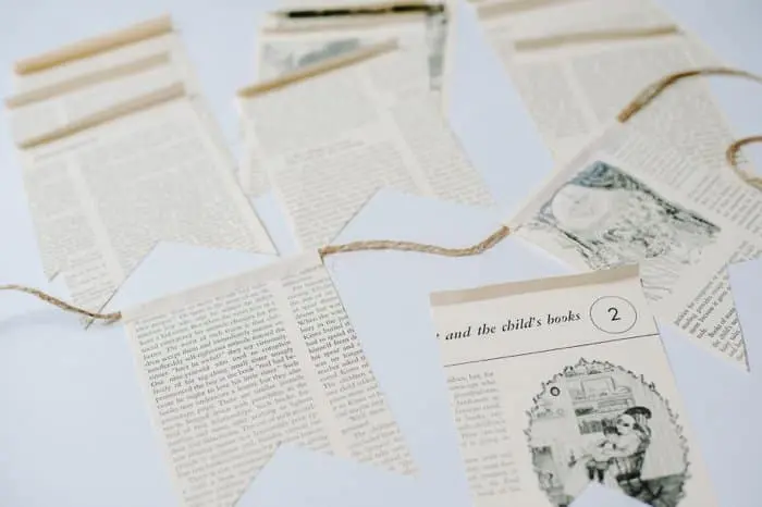 A bunting made up of cut out pages from an old book threaded on a twine string.