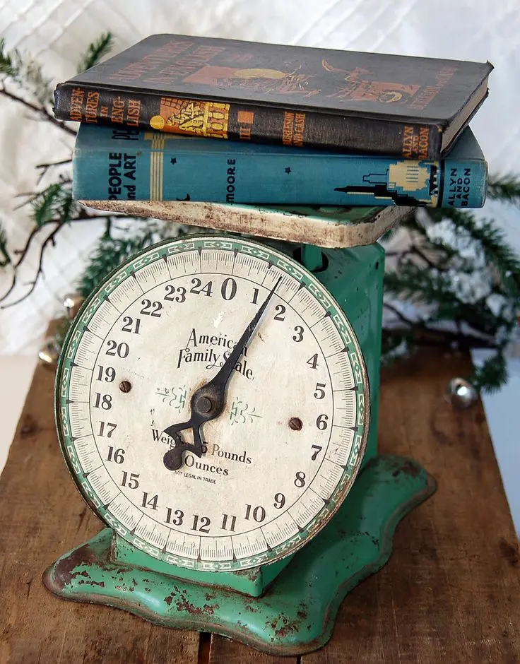 Two vintage books on an antique green kitchen scale.