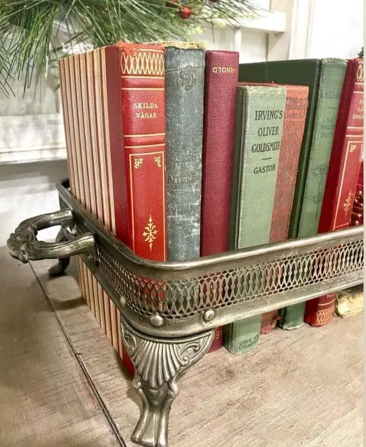 Green and red toned vintage books arranged into an antique decorative container.