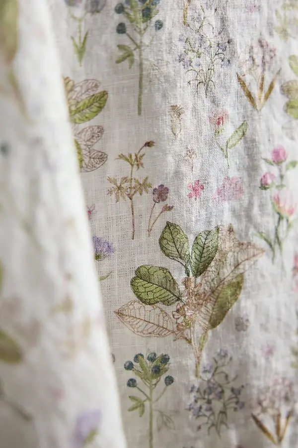 A closeup view of a linen fabric with a botanical illustration.