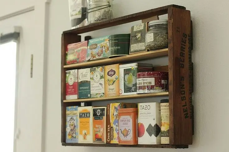 A vintage wooden crate used as a shelf for tea.