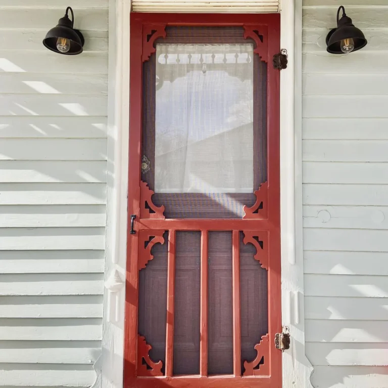 A view of an ornate Victorian door painted red with a white trim.