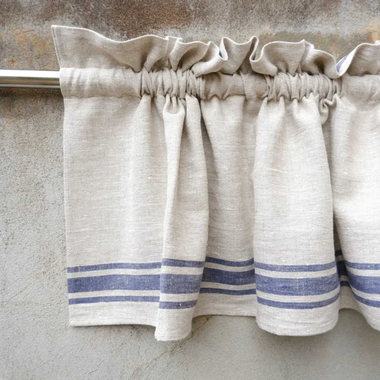 A pleated French ticking stripe linen cafe curtain on a curtain rod.