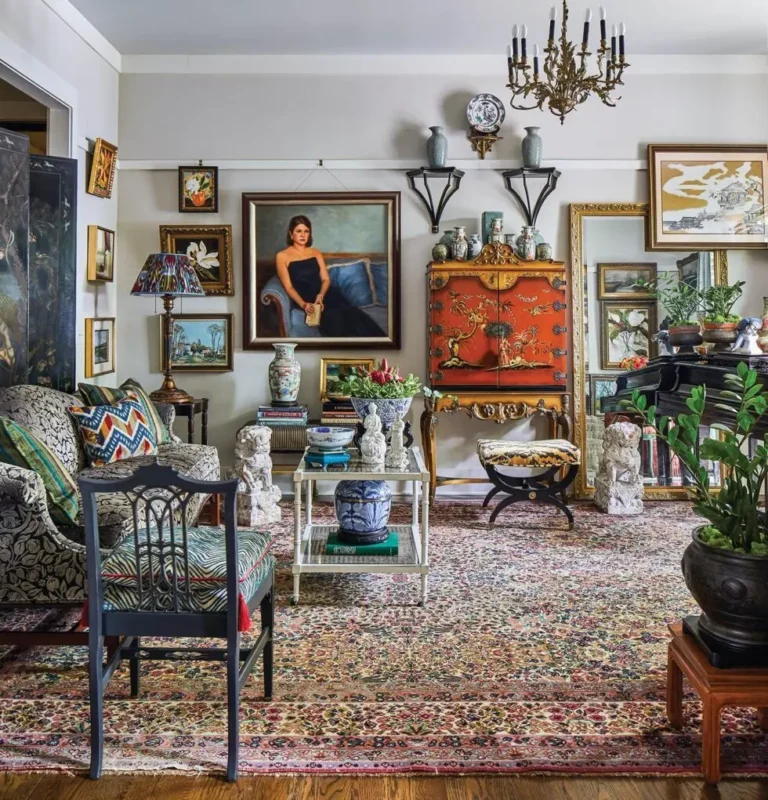 Vintage maximalist decor with oriental accents, ornate furniture, layered artwork, and eclectic patterned rugs.