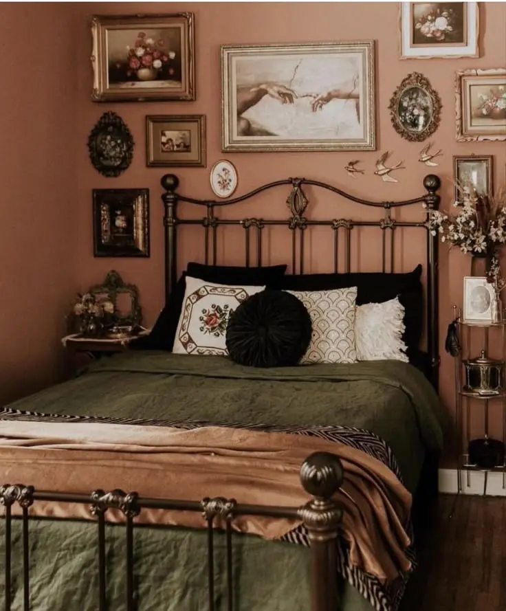 Cozy vintage bedroom with an iron bed frame, gallery wall art, and warm earthy tones.