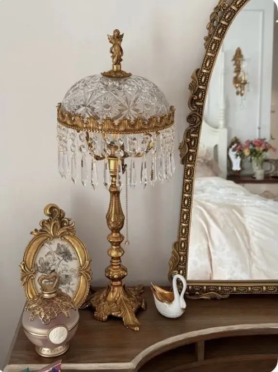 Cozy vintage bedroom with layered quilts, floral accents, antique wooden bed frame, and romantic pastel decor.